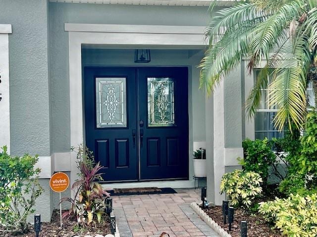 doorway to property featuring stucco siding