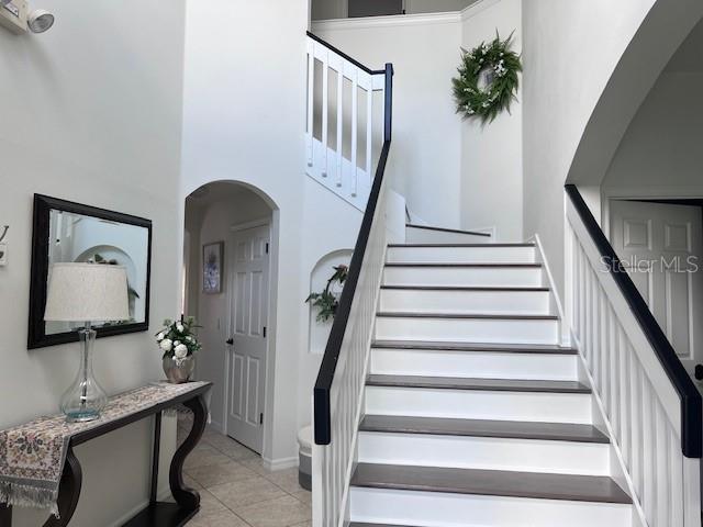 stairs featuring a high ceiling and tile patterned floors