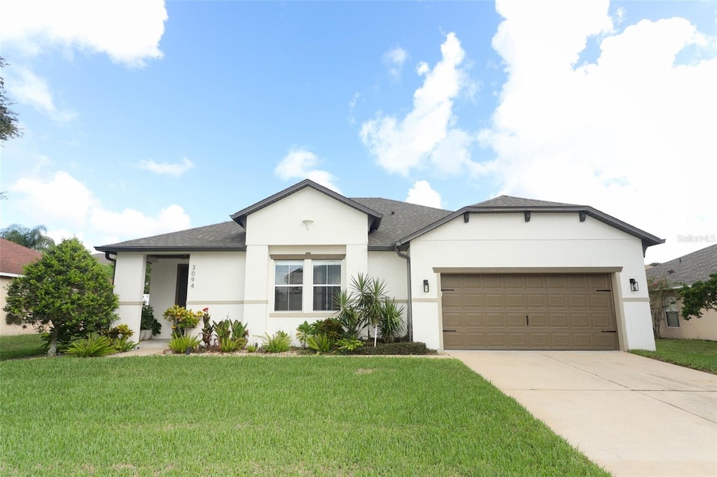 single story home featuring a garage and a front lawn