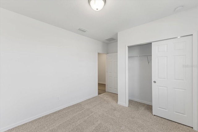 unfurnished bedroom with light carpet and a closet