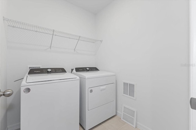 laundry area featuring light tile patterned flooring and washer and dryer