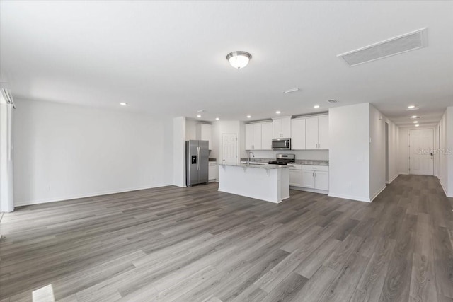 kitchen with white cabinetry, sink, stainless steel appliances, light hardwood / wood-style floors, and a kitchen island with sink