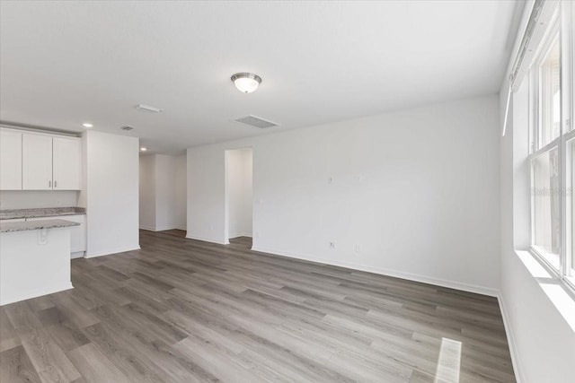 unfurnished living room featuring light wood-type flooring and a wealth of natural light