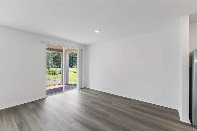 unfurnished room with dark hardwood / wood-style flooring