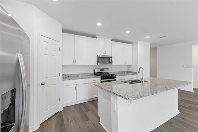 kitchen with appliances with stainless steel finishes, a center island with sink, white cabinetry, and sink