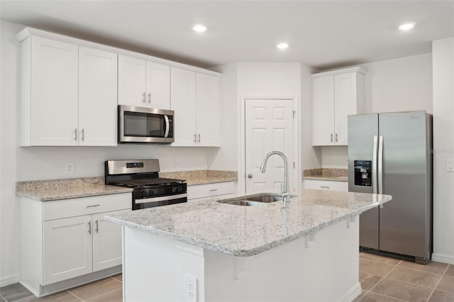 kitchen featuring sink, white cabinets, stainless steel appliances, and a center island with sink