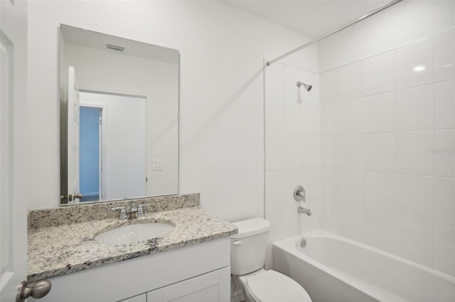 full bathroom with vanity, tiled shower / bath combo, and toilet