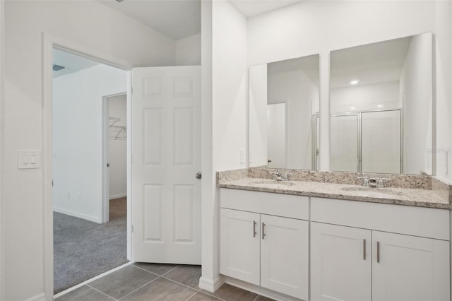 bathroom with tile patterned floors, vanity, and walk in shower