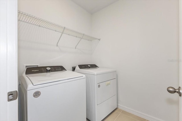 laundry room with washing machine and dryer and light tile patterned floors