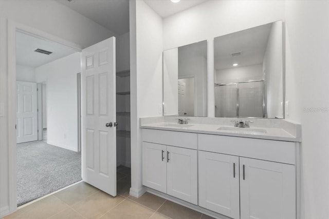 bathroom featuring tile patterned flooring, vanity, and an enclosed shower