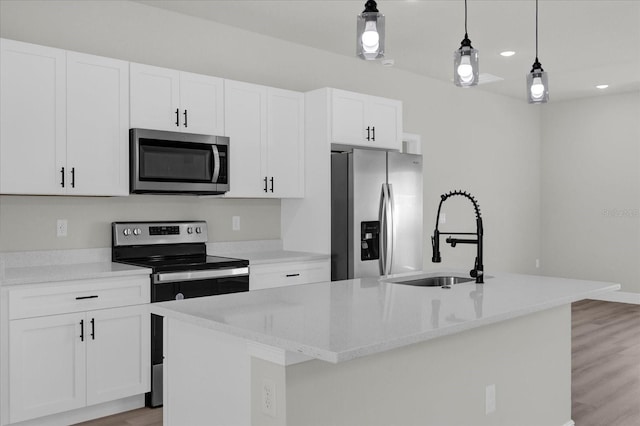 kitchen with stainless steel appliances, white cabinets, a kitchen island with sink, and hanging light fixtures