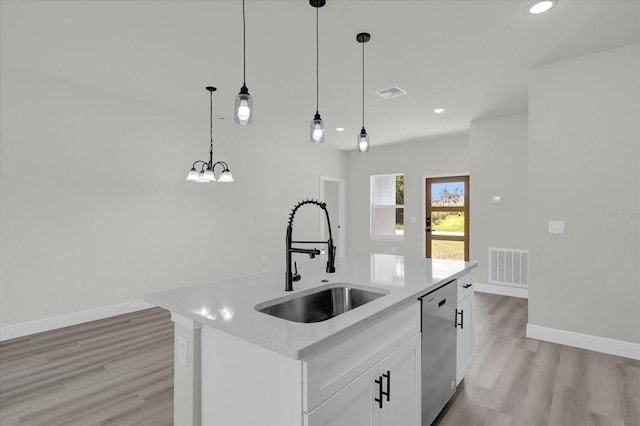 kitchen with an island with sink, dishwasher, white cabinetry, and sink