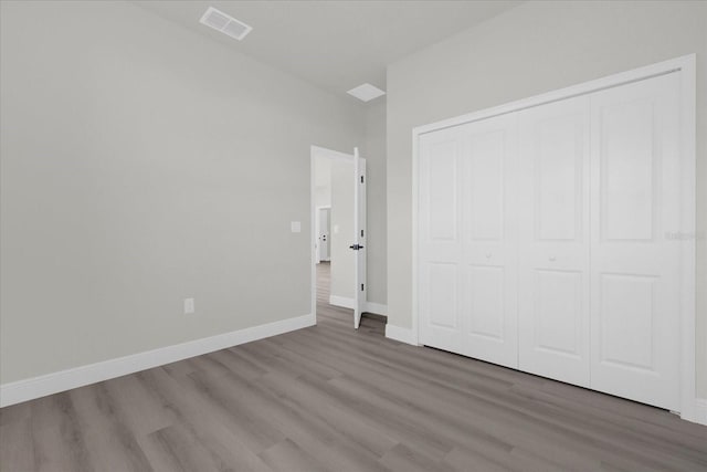 unfurnished bedroom with hardwood / wood-style floors and a closet