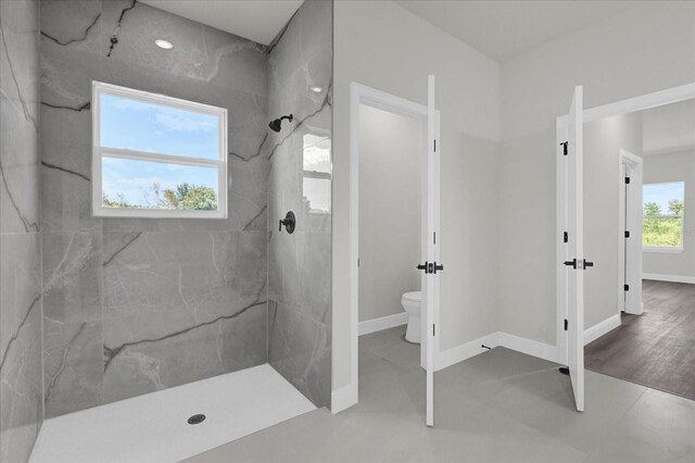 bathroom featuring toilet and tiled shower