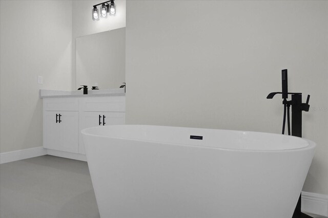 bathroom with concrete flooring, a bathtub, and vanity