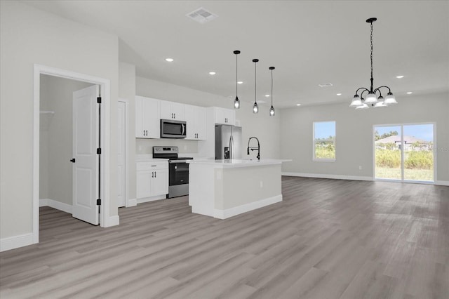 kitchen featuring light wood finished floors, stainless steel appliances, recessed lighting, and open floor plan