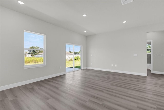 unfurnished room with recessed lighting, wood finished floors, and visible vents