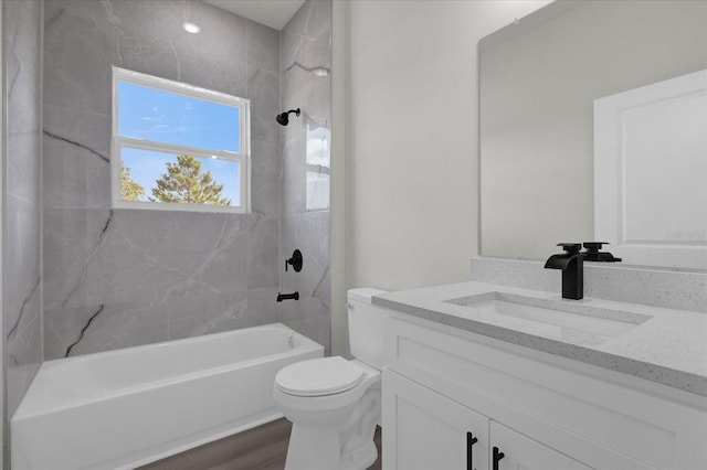 full bath featuring vanity, washtub / shower combination, wood finished floors, and toilet