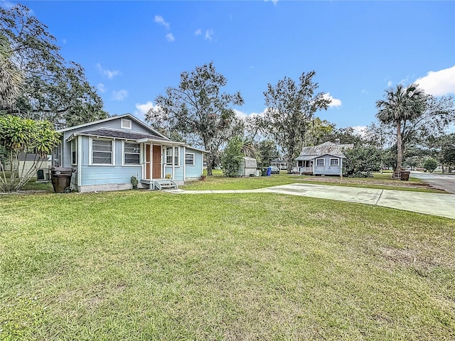 view of front of property featuring concrete driveway and a front lawn