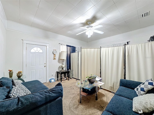 carpeted living room featuring ceiling fan and ornamental molding