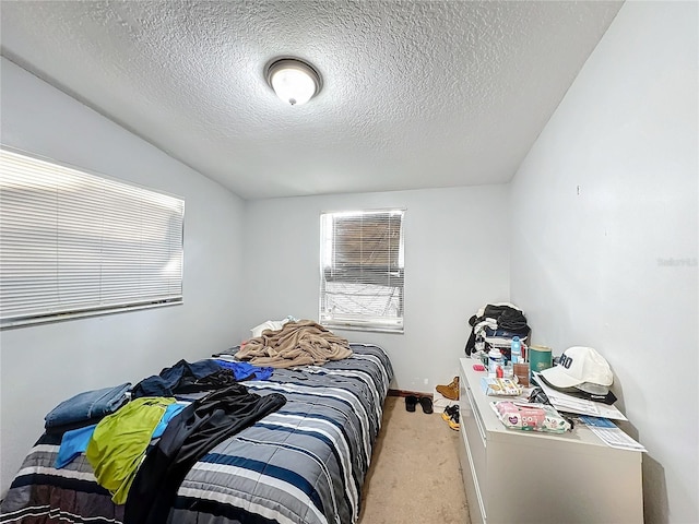 bedroom with a textured ceiling, light colored carpet, and vaulted ceiling