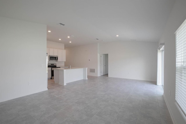 unfurnished living room with lofted ceiling and light tile patterned floors