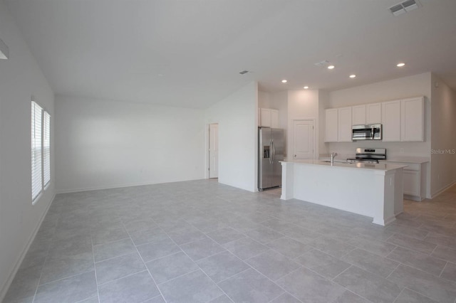 kitchen with white cabinetry, light tile patterned floors, appliances with stainless steel finishes, and a kitchen island with sink