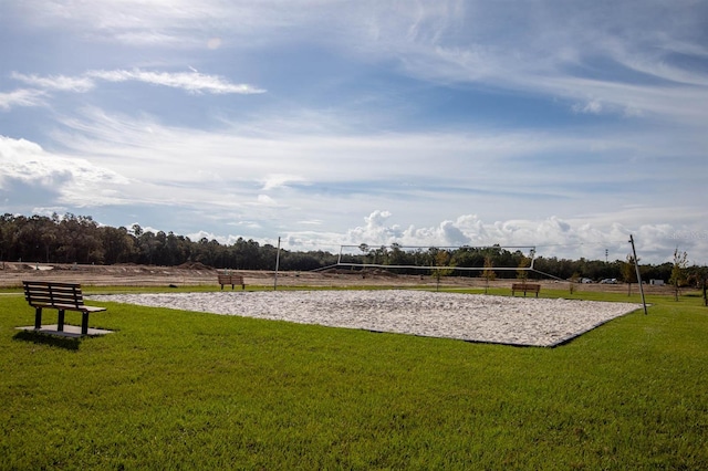 view of community featuring volleyball court, a rural view, and a yard