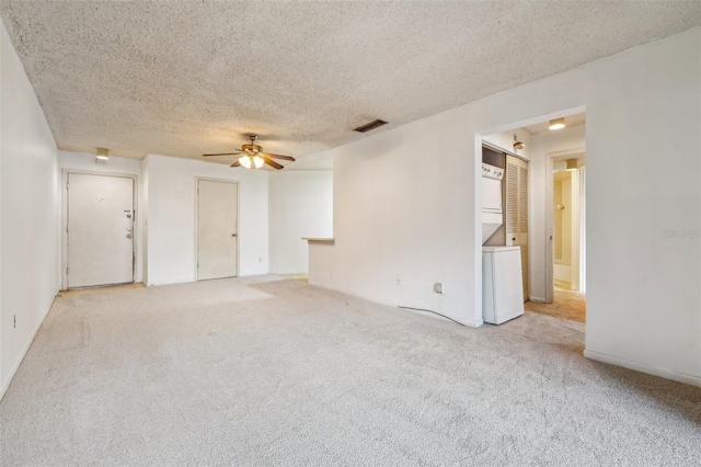 unfurnished room with ceiling fan, light colored carpet, and a textured ceiling