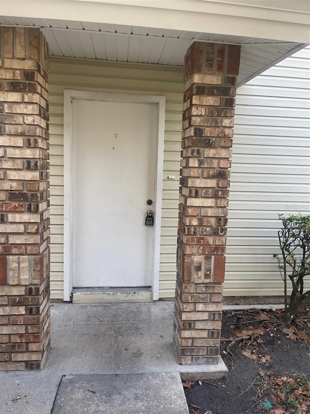 property entrance featuring brick siding