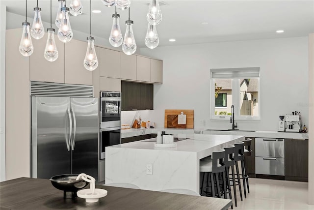 kitchen featuring light stone counters, hanging light fixtures, a kitchen island, stainless steel appliances, and a breakfast bar area