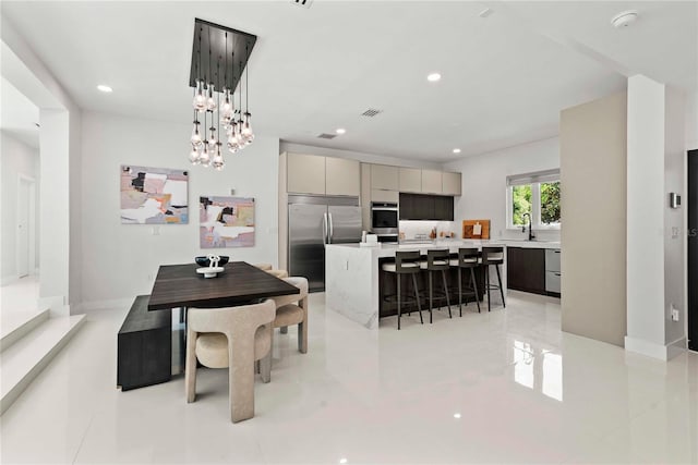 dining area featuring an inviting chandelier, light tile patterned floors, and sink