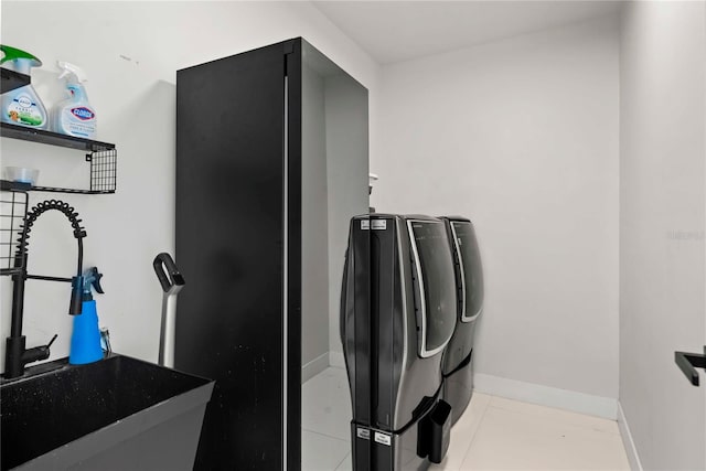 washroom with light tile patterned flooring, sink, and washer and dryer