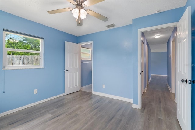 unfurnished bedroom with wood-type flooring, a closet, and ceiling fan