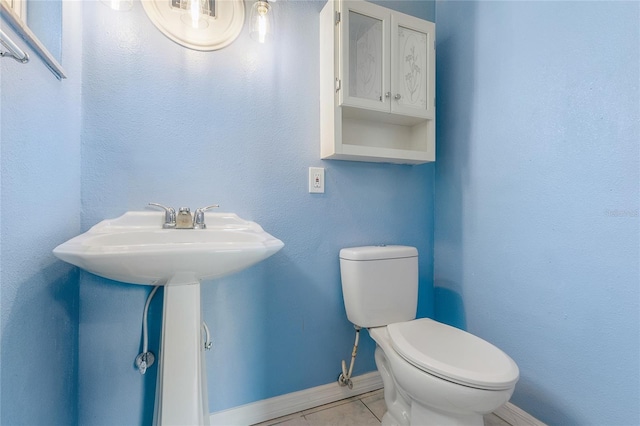 bathroom featuring toilet and tile patterned flooring