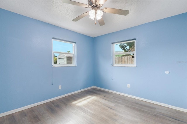 926 Everett St, Lake Alfred, FL 33850 - unfurnished room with healthy amount of natural light, wood finished floors, baseboards, ceiling fan, and a textured ceiling
