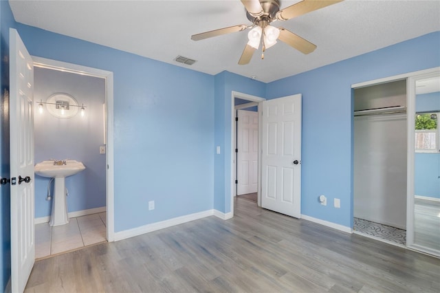 unfurnished bedroom featuring a textured ceiling, ceiling fan, a closet, and hardwood / wood-style floors