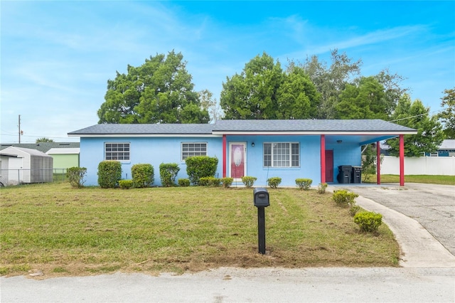 ranch-style home featuring a carport and a front yard