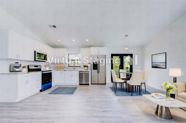 kitchen with hanging light fixtures, a wealth of natural light, stainless steel appliances, and white cabinets