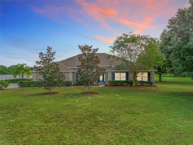 single story home featuring a lawn and a garage