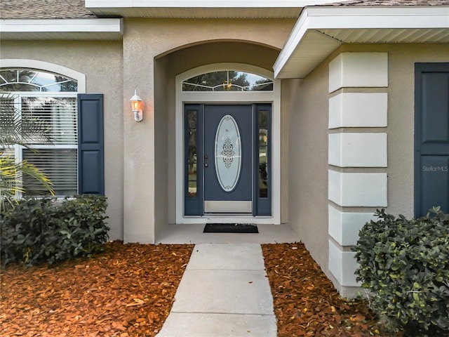 entrance to property featuring stucco siding
