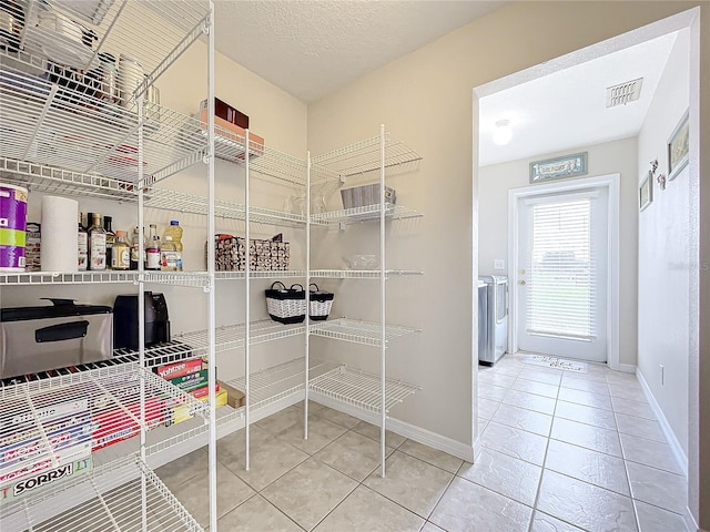 storage area featuring visible vents and washer / clothes dryer