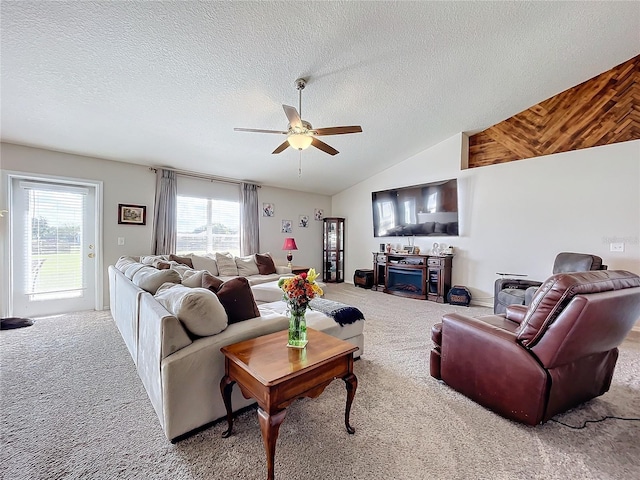 carpeted living area with vaulted ceiling, a textured ceiling, and ceiling fan