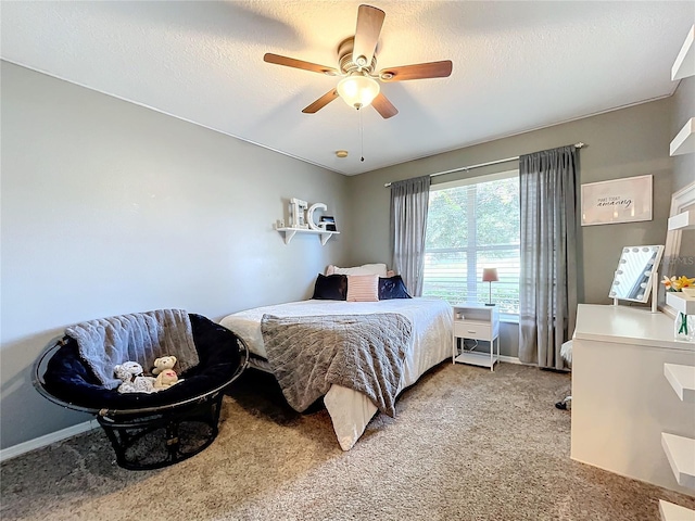 bedroom with ceiling fan, a textured ceiling, baseboards, and light carpet