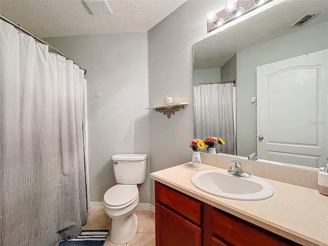 bathroom with a textured ceiling, a shower with shower curtain, tile patterned floors, vanity, and toilet