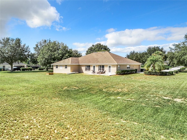 back of property featuring a yard