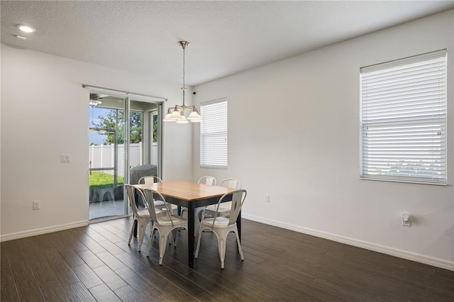 dining space featuring a textured ceiling, dark hardwood / wood-style floors, and a healthy amount of sunlight