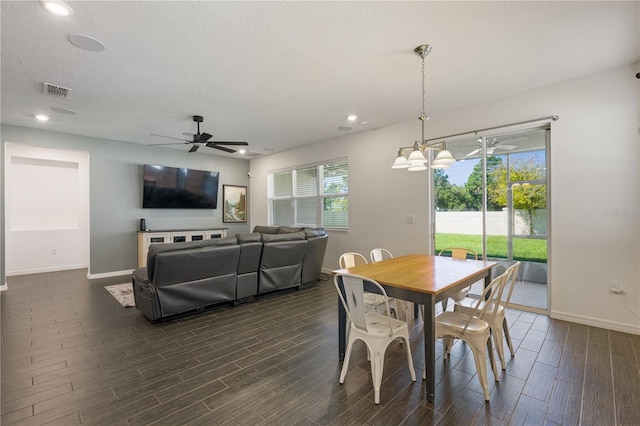 dining room featuring a textured ceiling, dark hardwood / wood-style floors, and ceiling fan with notable chandelier