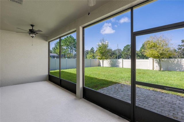 unfurnished sunroom featuring ceiling fan