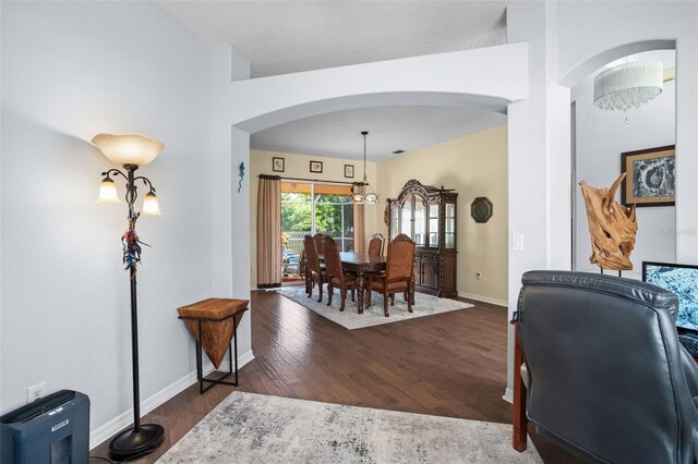 interior space featuring an inviting chandelier and dark wood-type flooring